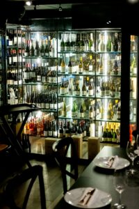 Wine tasting room with bottles displayed on shelves in a dimly lit establishment