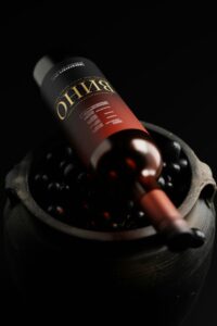Wine bottle on a wooden barrel showcasing artisan winery branding and positioning