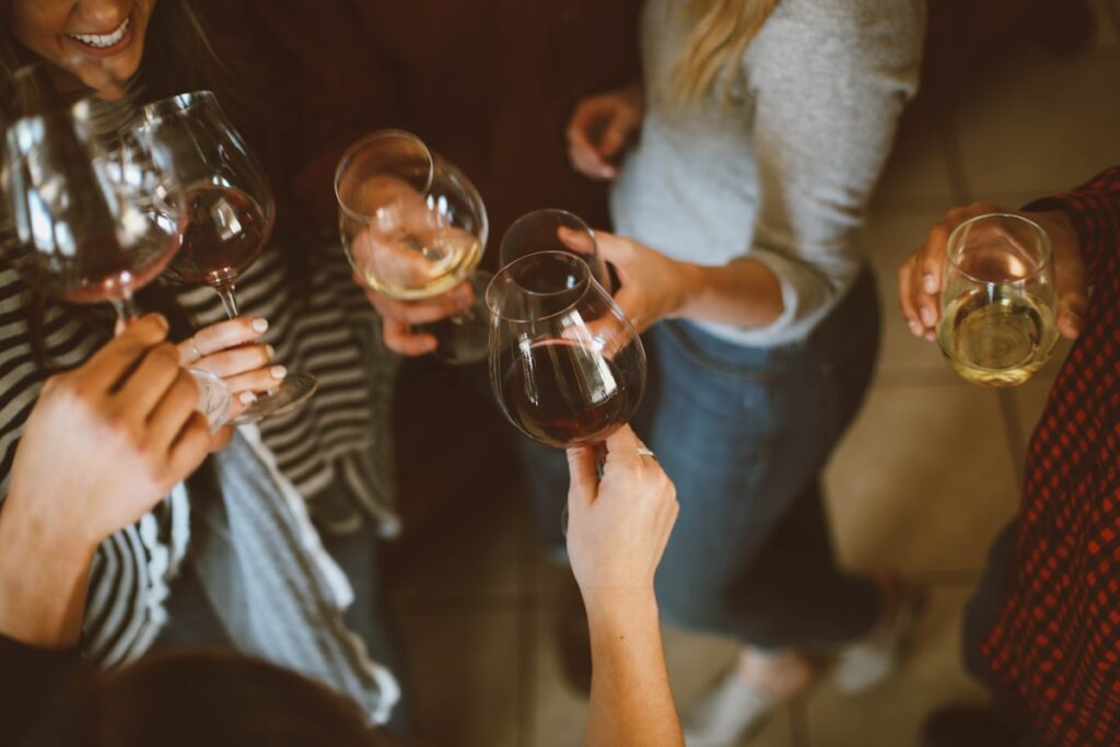 Group of people tossing wine glasses in a celebratory toast