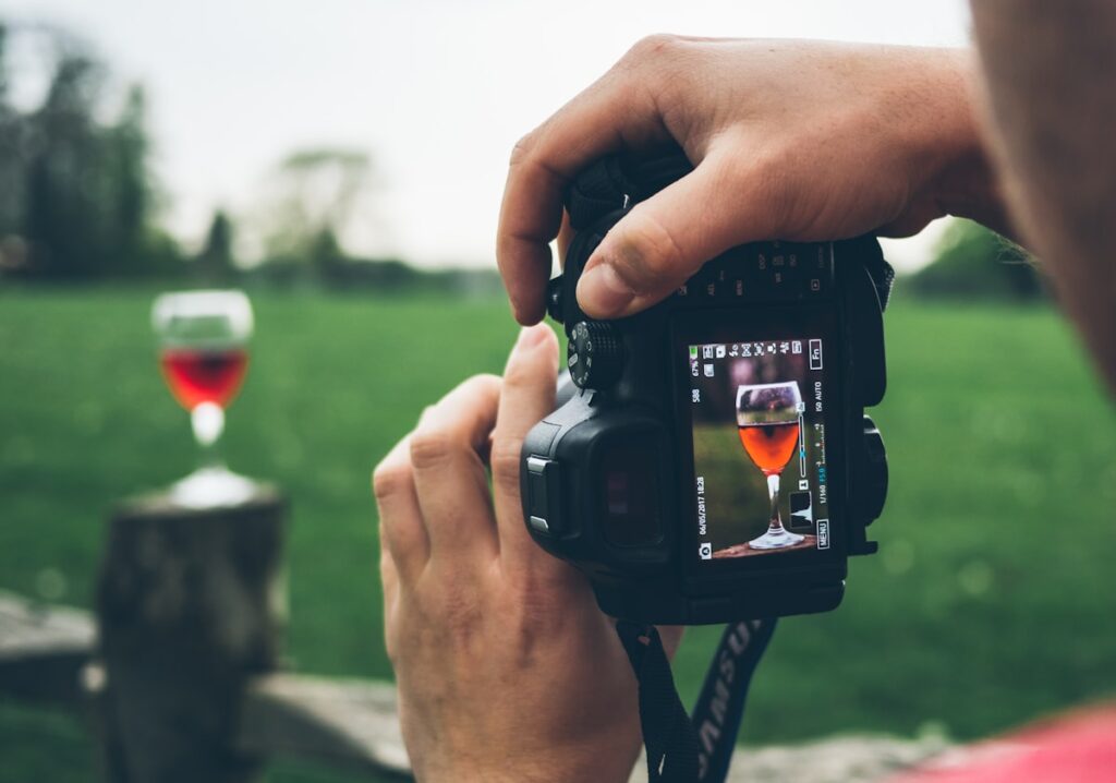 Wine glass being photographed through a camera viewfinder for content creation