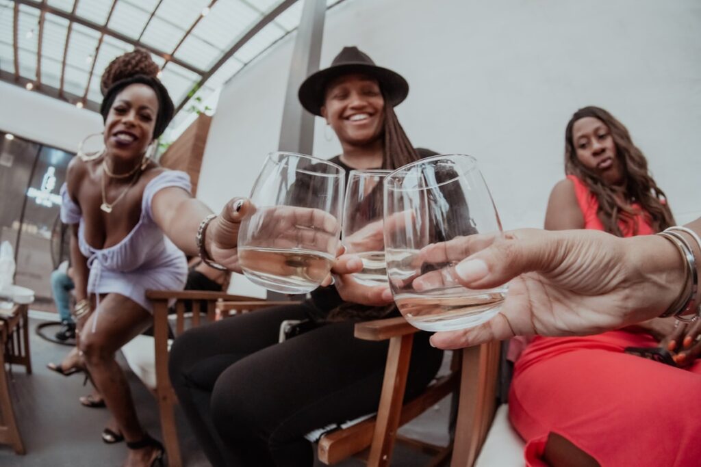 People tossing clear wine glasses in celebration