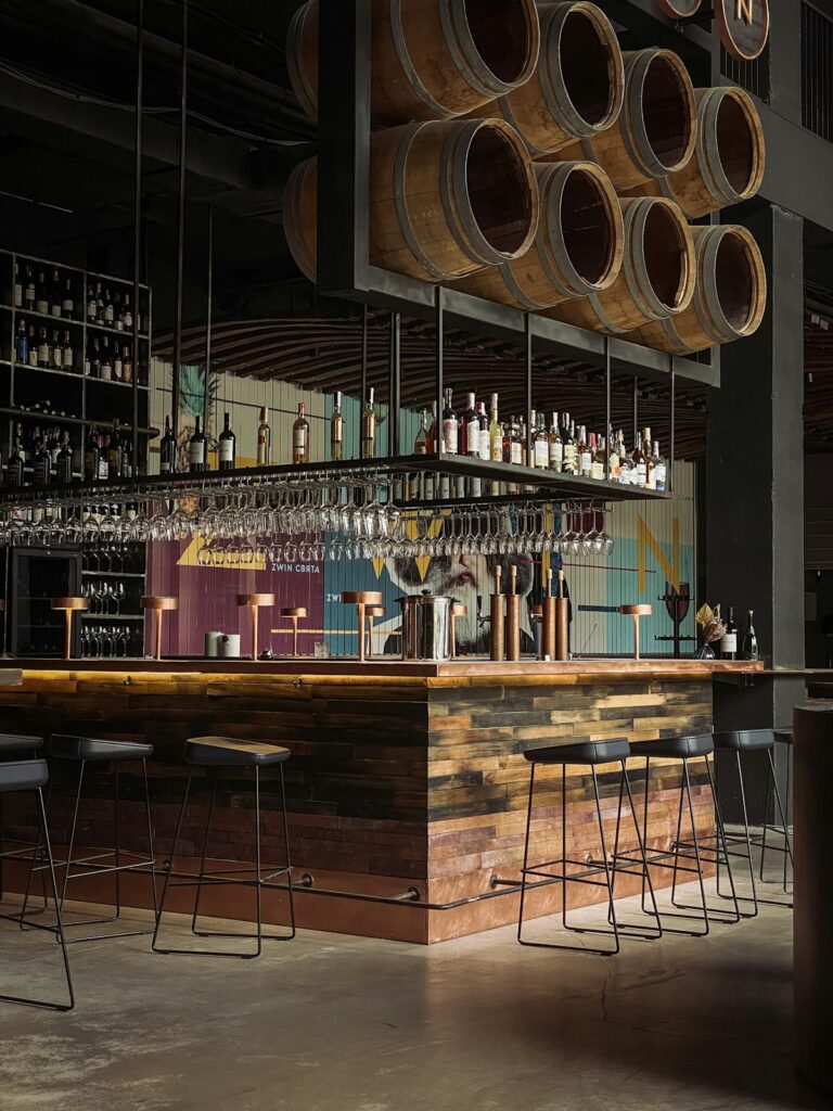 Elegant winery bar counter with wine bottles displayed on wooden shelving
