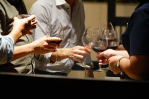 Group of people toasting with glasses of red wine in appreciation