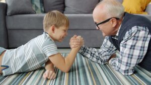 Grandfather and grandson sharing playful moment together on floor