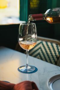 Rose wine being poured into elegant glass as gift moment