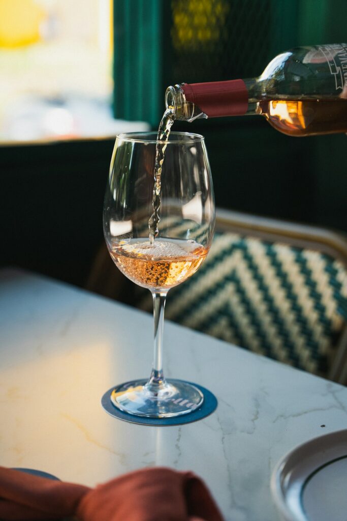 Rose wine being poured into elegant glass as gift moment