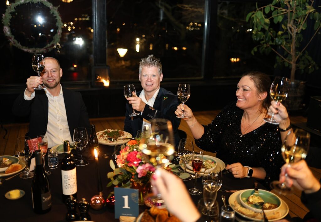 People toasting wine glasses at intimate dinner gathering