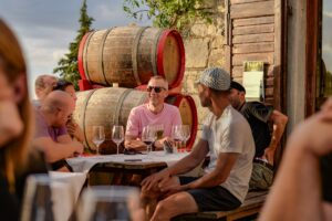 People enjoying wine tasting at a winery surrounded by barrels